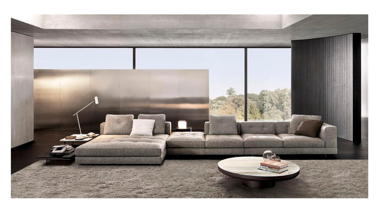 Modern living room with a large gray sectional sofa, coffee table, and decorative items.