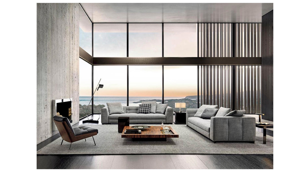 Modern living room with gray sofa, coffee table, and large windows overlooking a scenic view.