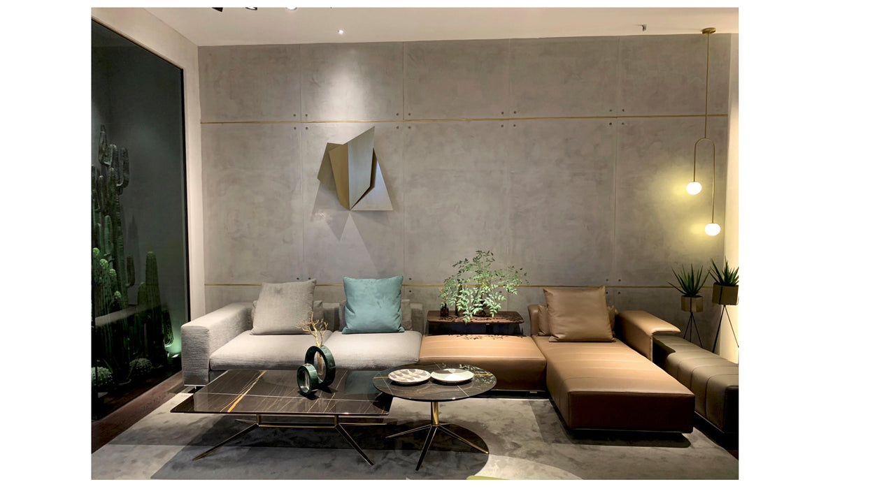 Modern living room with a gray wall, sectional sofa, and decorative items.