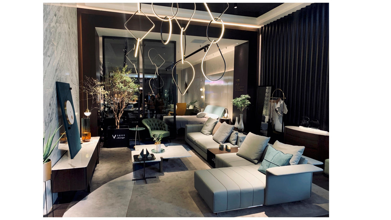 Modern living room with a gray sectional sofa, decorative plants, and stylish decor.