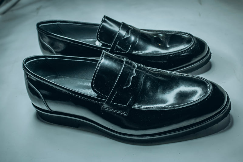 Salvatore Ferragamo black patent leather penny loafers|a classic style of formal and semi-formal footwear.