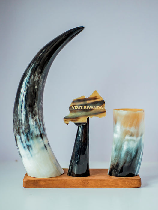 Decorative set with large horn-like sculptures on a wooden base against a light gray background.