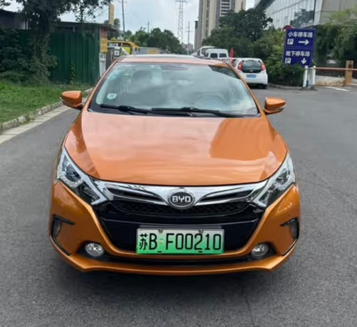 Orange BYD car on a road with a blurred background