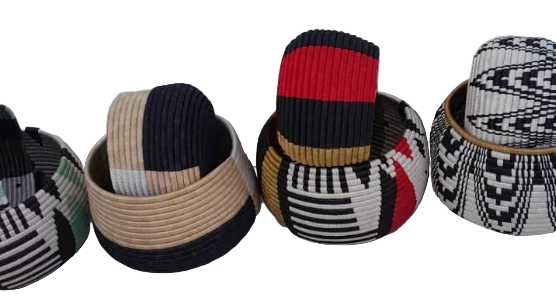 A collection of beige, black, red, and multicolored woven jewelry items, including bracelets and a hat.
