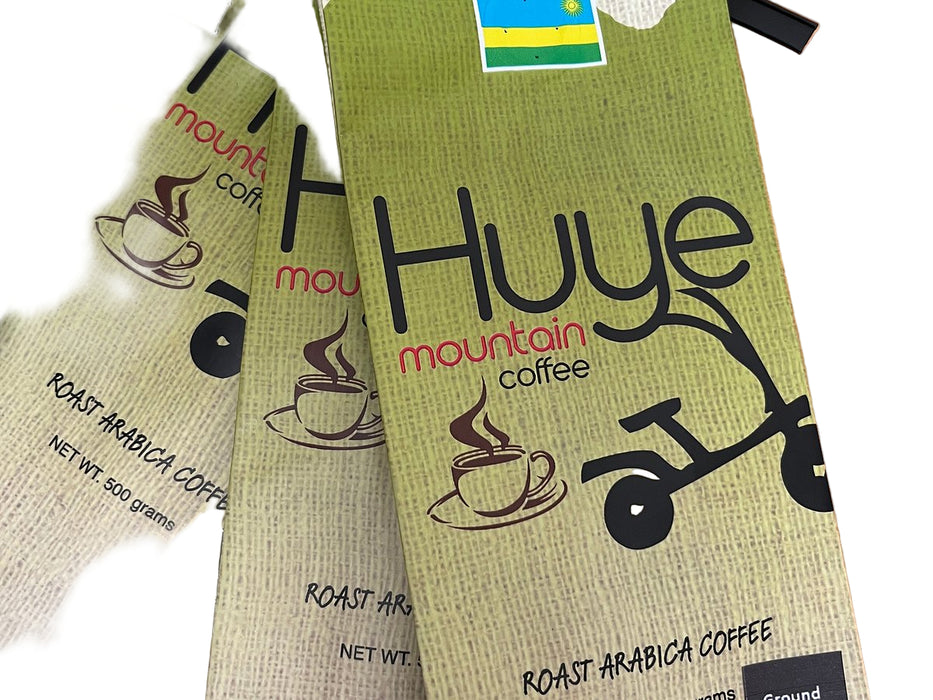 Three packages of Huye mountain coffee on a wooden surface