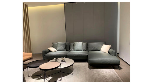 Modern gray sectional sofa in a living room setting with a neutral color palette.