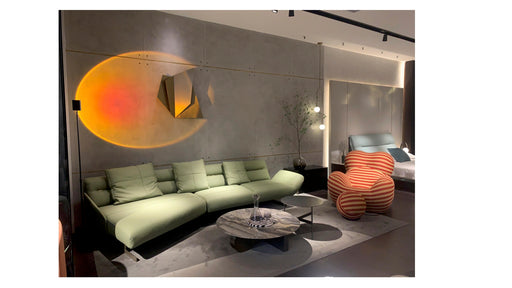 Modern living room with a green sofa, round coffee table, and abstract wall art.