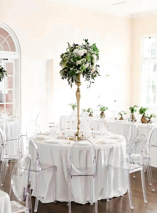 Decorative table setting with floral centerpiece in a room with large windows.