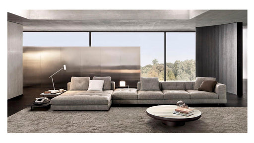 Modern living room with a large gray sectional sofa, coffee table, and decorative items.