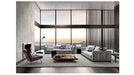 Modern living room with gray sofa, coffee table, and large windows overlooking a scenic view.