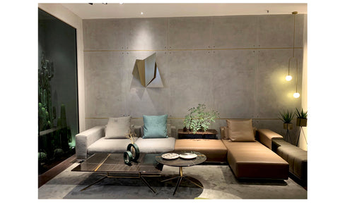 Modern living room with a gray wall, sectional sofa, and decorative items.
