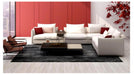 Modern living room with white sectional sofa, red accent pillows, and a coffee table.